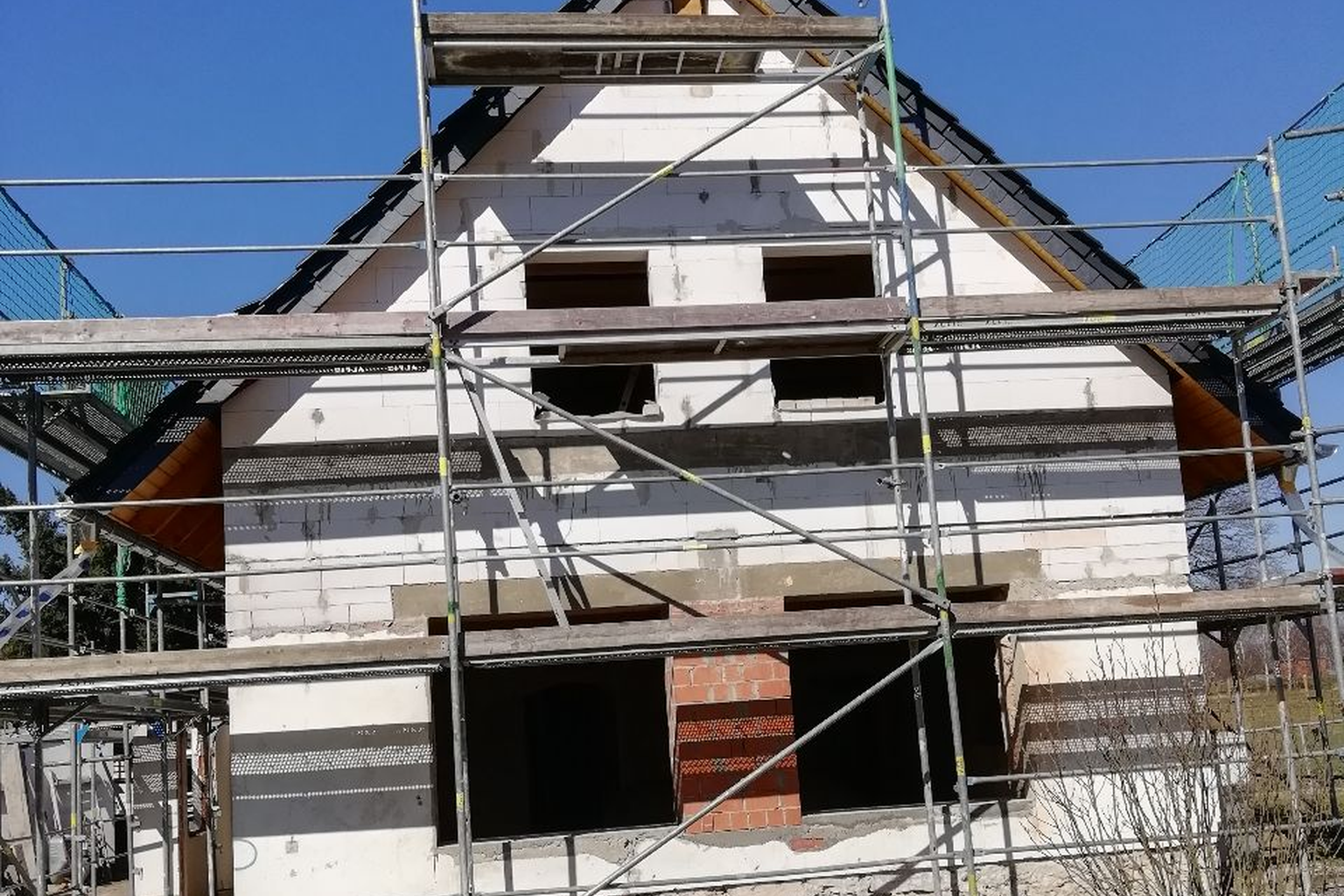 Rohbau mit sichtbaren Holzelementen an Giebel und Dachüberstand